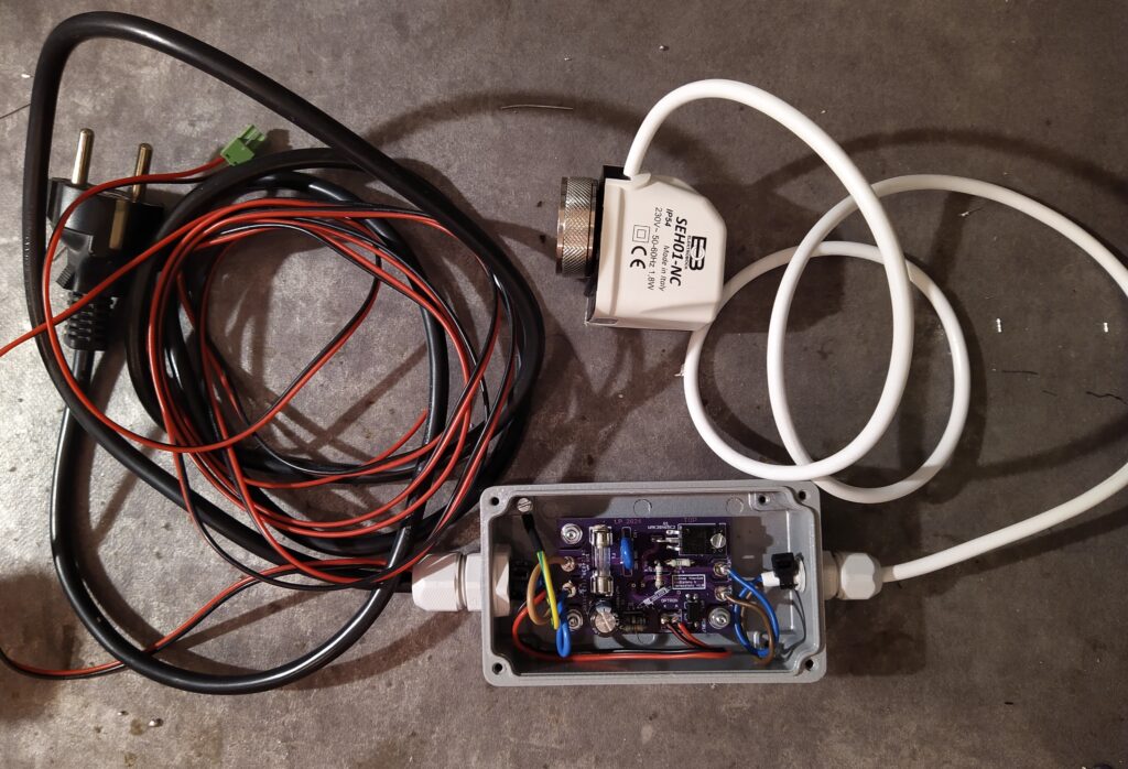 Elektronika radiátoru k pokojovému termostatu v krabičce s kabely.