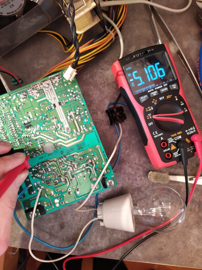 Testování pomocného zdroje v ATX zdroji EVOLVE po opravě. Zdroj je do sítě zapojen přes žárovku 60 W.