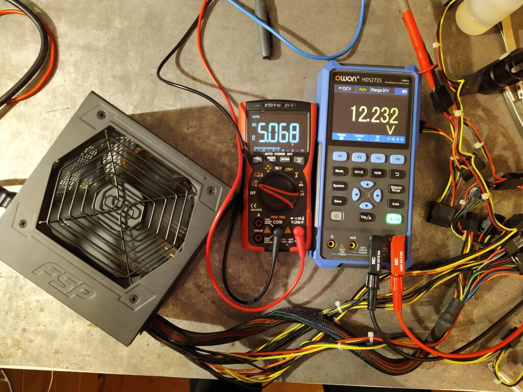 Kontrola výstupních napětí +5 V a +12 V u zdroje FSP HE-500 po opravě.