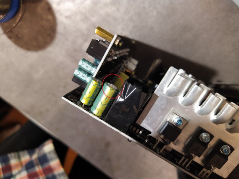 Detail na nafouklý elektrolytický kondenzátor na sekundární straně pomocného zdroje v PC zdroji Gigabyte P750GM.