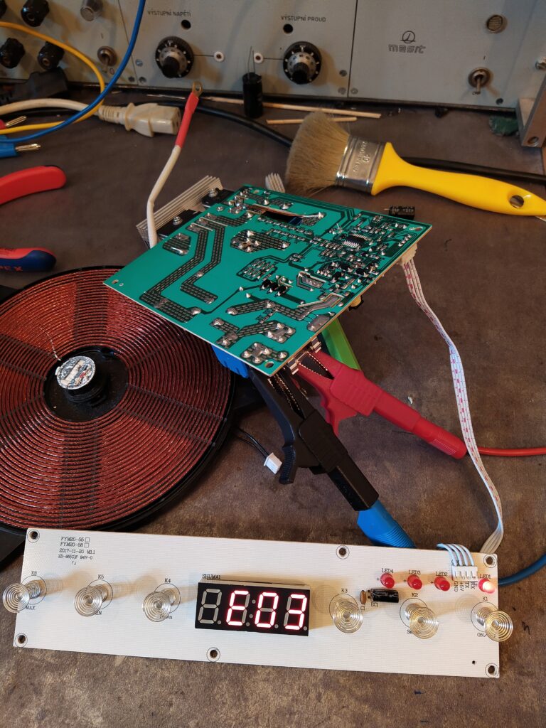 Testování opraveného indukčního vařiče G3Ferrari G10061 na stole s připojeným ovládacím panelem, ale zatím bez připojené plotýnky.