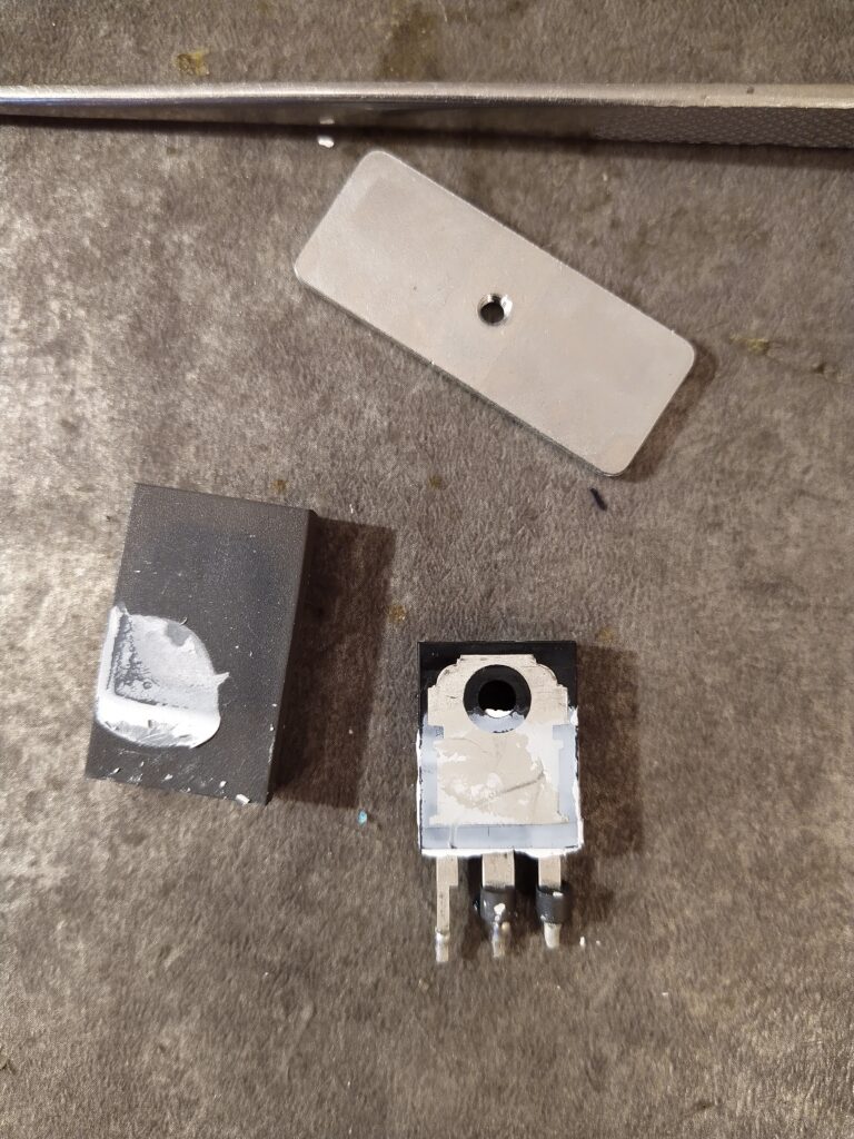 První tranzistor PFC ze zdroje Meanwell NDR-480-24. Teplovodivá pasta nepokrývá celou chladicí plochu tranzistoru ani izolační podložky.